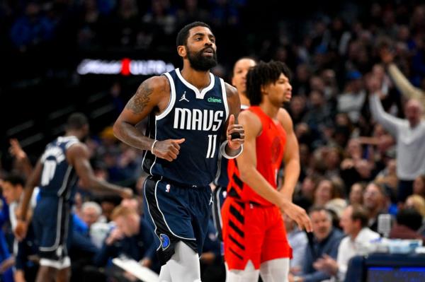 Dallas Mavericks guard Kyrie Irving (11) celebrates after making a basket against the Portland Trail Blazers during the second quarter at the American Airlines Center.