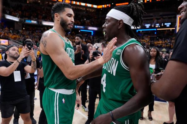 Boston Celtics forward Jayson Tatum, left, celebrates with teammate guard Jrue Holiday (4) after Game 4 of the NBA Eastern Co<em></em>nference basketball finals against the Indiana Pacers