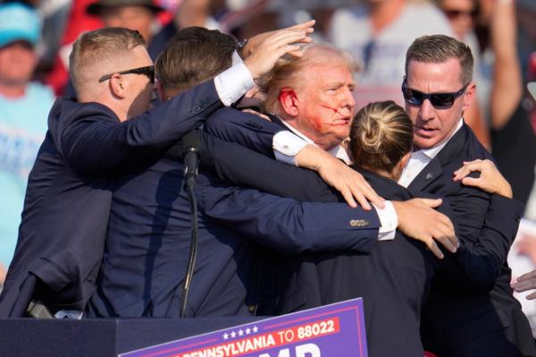 Republican presidential candidate former President Do<em></em>nald Trump is surrounded by U.S. Secret Service agents as he is helped off the stage at a campaign rally in Butler, Pa., Saturday, July 13, 2024. 