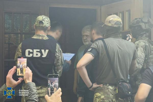 Ukranian law enforcement officials at the door of a home being answered by a bearded man, Igor Kolomoisky.