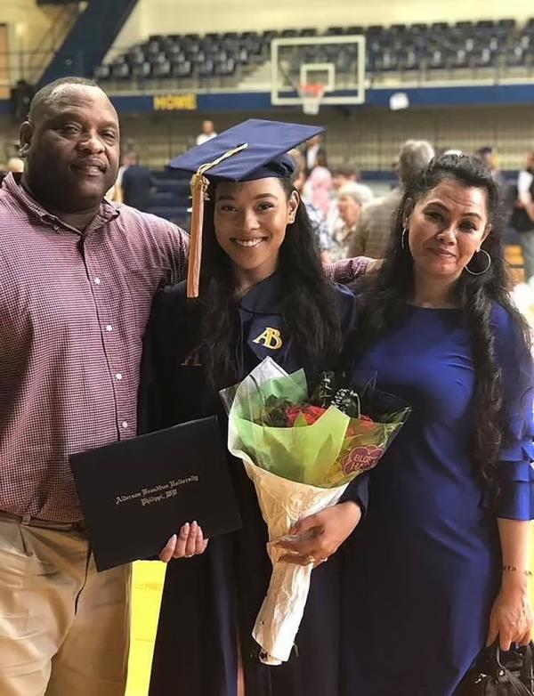 Christina Johnson is pictured with her parents at her college graduation.