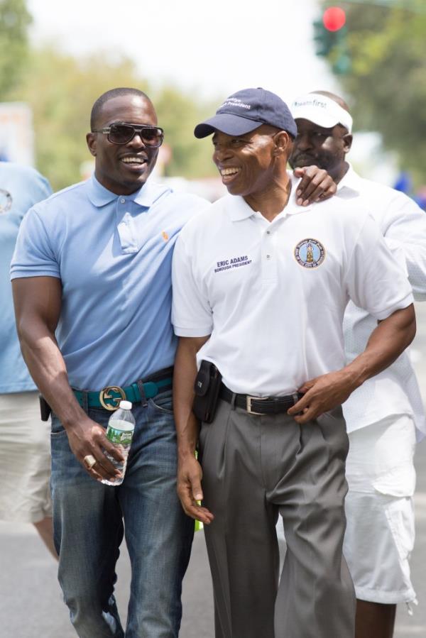 Lamor Whitehead puts his arm around Eric Adams, then Brooklyn borough president, as they walk outside at a parade in 2016. 