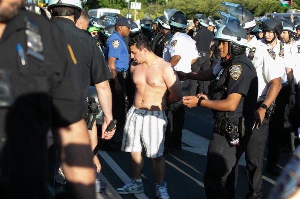 A protester is taken into custody in front of the Brooklyn Museum