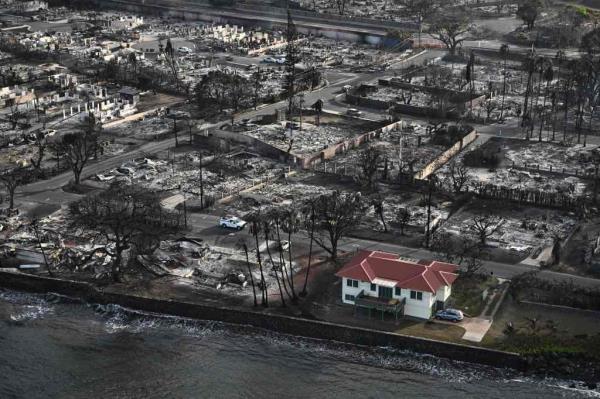 An aerial image shows a red roofed house that survived the fires surrounded by destroyed homes and buildings burned to the ground in the historic Lahaina in the aftermath of wildfires in western Maui 
