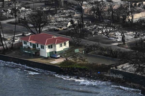 The single home that survived the wildfires seen in Lahaina flanked by piles of debris