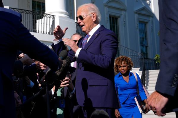 President Joe Biden discussing with reporters before leaving the White House, with press secretary Karine Jean-Pierre at his side.