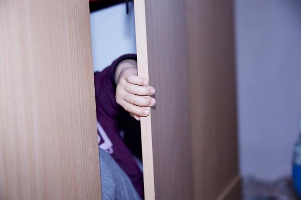 A child's hand touching a wooden surface