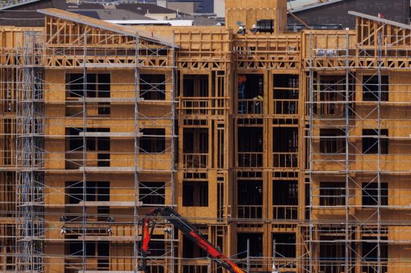 Co<em></em>nstruction workers build multifamily housing in San Diego.