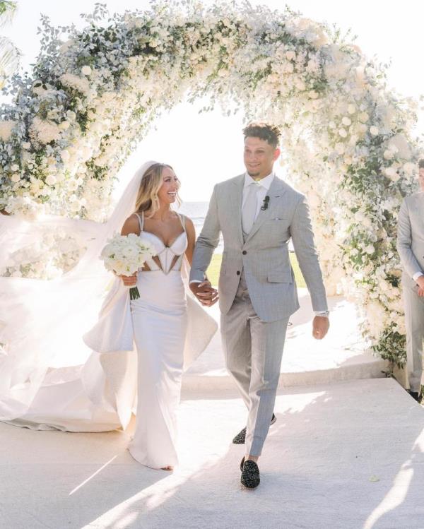 Patrick Mahomes and Brittany Matthews walking down the aisle on their wedding day.