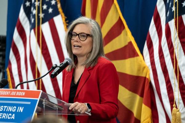 Arizona Governor Katie Hobbs speaking at podium at Amkor Technology Headquarters during announcement of federal funding agreement