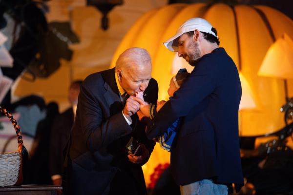 Biden playfully bites a baby's thigh during a Halloween event on Oct. 30 at the White House.