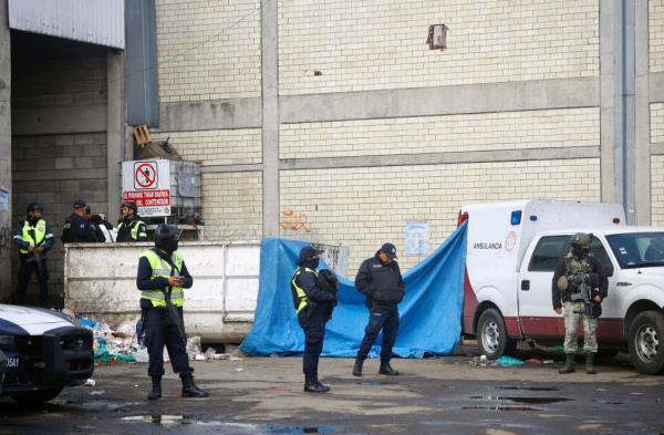 Police officers stand guard outside the site after a fire broke out in the Central de Abasto of Toluca, in Toluca, State of Mexico, Mexico, 10 July 2023. 