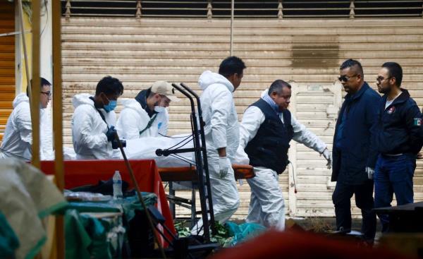 Forensic experts work at the site after a fire broke out in the Central de Abasto of Toluca, in Toluca, State of Mexico, Mexico, 10 July 2023.