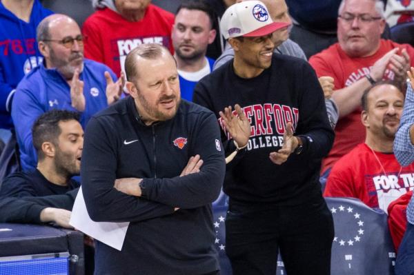 New York Knicks head coach Tom Thibodeau reacting on the ba<em></em>seline during a game against the Philadelphia 76ers, surrounded by cheering fans