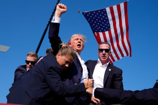Trump raises his fist after being shot.