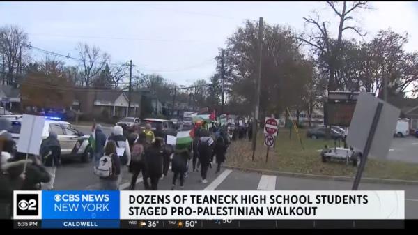 Teaneck High School students participating in pro-Palestinian rally by walking on a street.