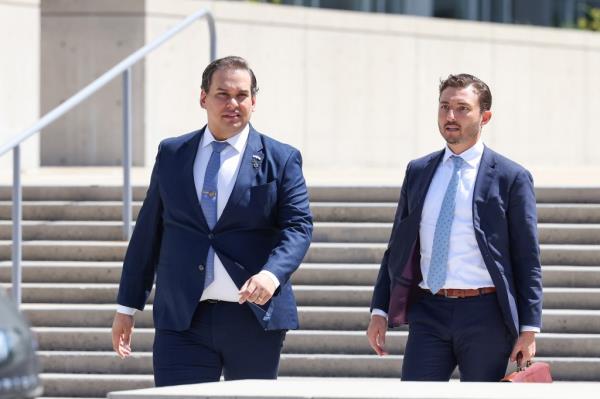 George Santos and another man in suits leaving Federal court in Central Islip, NY, walking up stairs