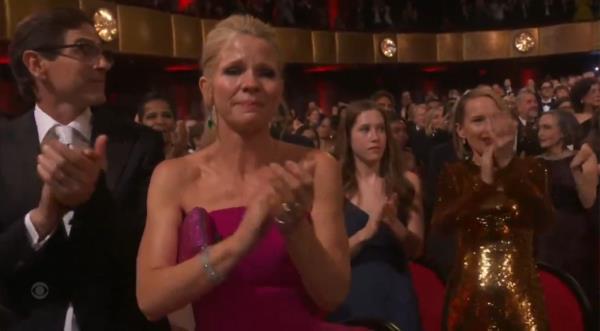 Hillary Clinton making a surprise appearance at the Tony Awards, receiving a standing ovation, as Kelli O'Hara and others clap.