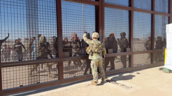 closed border wall gates guarded by soldiers 