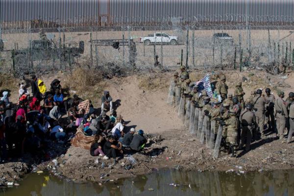 Migrants camp at the border, wher<em></em>e Texas authorities try to keep them from crossing