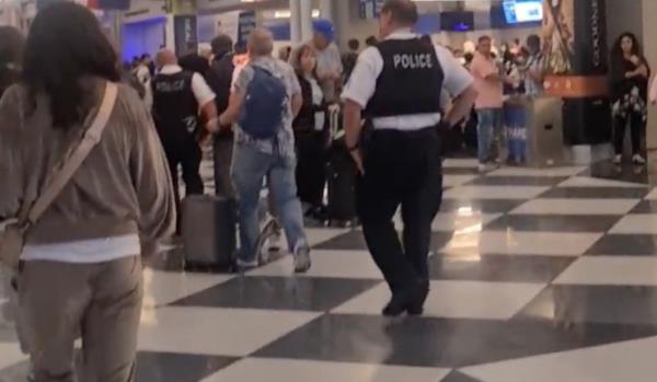 After a protracted argument, the man finally allowed himself to be led away by airport staff and police officers