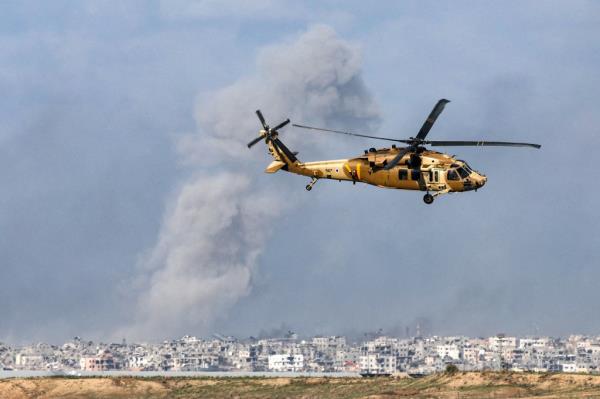 A picture taken from southern Israel near the border with the Gaza Strip on Dec. 6, 2023, shows a Black Hawk military transport helicopter flying near the border with the Palestinian territory on Dec. 6, 2023. 