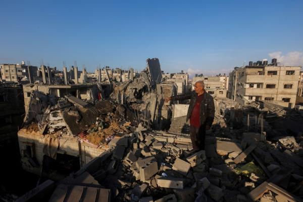 A Palestinian man gestures as he inspects the site of Israeli strikes in Khan Younis in the southern Gaza Strip on Dec. 6, 2023. 