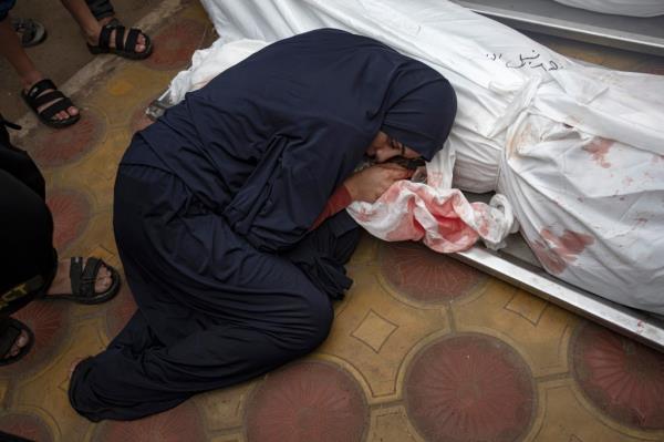 A woman mourns her child and her husband killed in an Israeli army bombardment of the Gaza Strip, in the hospital in Khan Younis, on Dec. 5, 2023.