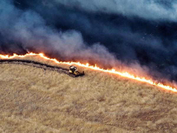 A tractor working to co<em></em>ntain the Corral Fire line in California, amidst strong winds and dry grass
