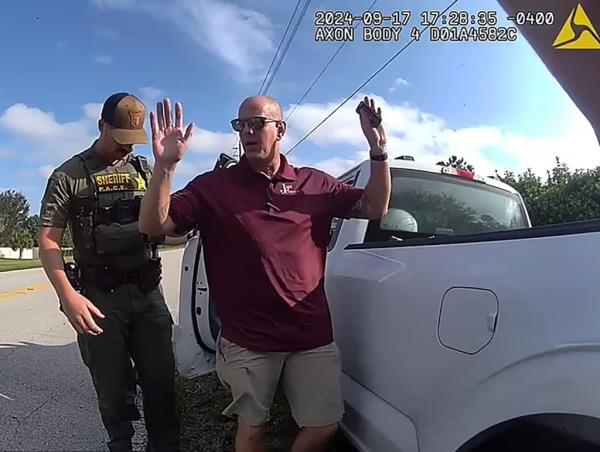 Man with hands up while being arrested. 