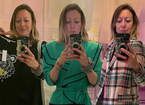 Three pictures of Jen Barton Packer at the clothes swap - all mirror selfies. Left: Jen holding a black jumper on a rail; middle: Jen trying on a green jacket; right: Jen trying on a checked jacket.