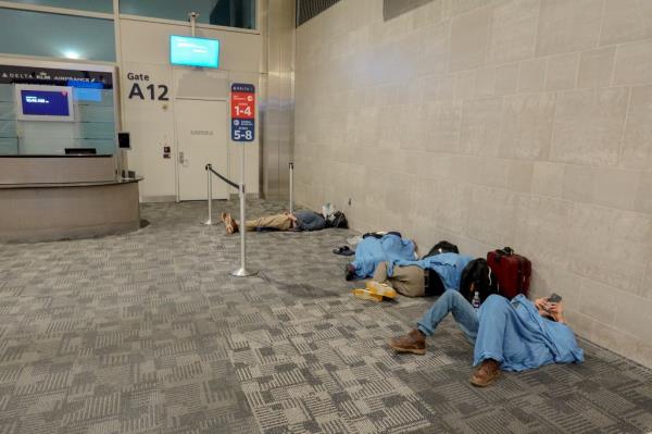 Passengers laying on airport floor.