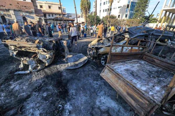 People search through debris outside the site of the Ahli Arab hospital in central Gaza on October 18, 2023 in the aftermath of an overnight blast there. 