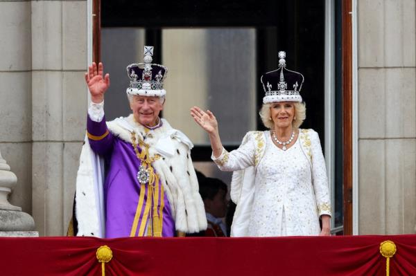Britain's King Charles and Queen Camilla gesture as they stand on the Buckingham Palace balcony following their coro<em></em>nation ceremony on May 6.
