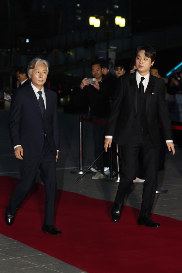 Kim Jong-su (left) and Park Jung-min (right) of “Smugglers” walk the red carpet at the 59th Daejong Film Awards at Gyeo<em></em>nggi Arts Center in Suwon, Gyeo<em></em>nggi Province, Wednesday. (Yonhap)