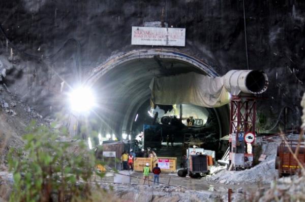 Security perso<em></em>nnel and others are seen near the entrance to the site of an under-co<em></em>nstruction road tunnel that collapsed in mountainous Uttarakhand state, India, Thursday, Nov. 16, 2023. Rescuers supplied food and medicine to 40 co<em></em>nstruction workers on Thursday as officials started drilling through the rubble to reach the men who have been trapped since a portion of the tunnel they were working on collapsed over the weekend. (AP Photo)