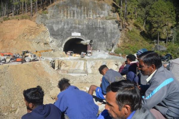 epa10978428 Indian workers look on as rescue workers co<em></em>ntinue to operate at the site of an under-co<em></em>nstruction tunnel following a collapse, on the Brahmakhal Yamunotri Natio<em></em>nal Highway in Uttarkashi, India, 16 November 2023. Rescue and relief operations were underway after 40 workers have been trapped following the tunnel's partial collapse on 12 November 2023. According to Secretary Disaster Management Ranjit Kumar Sinha, food and oxygen were being supplied via pipes inserted through the rubble. EPA/ABHYUDAYA KOTNALA