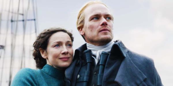 Caitríona Balfe as Claire Fraser snuggling against Sam Heughan as Jamie Fraser in the Outlander season 7 midseason finale