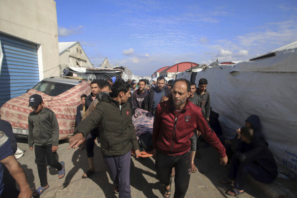 Palestinians carry a a body of a person killed in the Israeli bombardment at a building of an UNRWA vocatio<em></em>nal training center which displaced people use as a shelter in Khan Younis.