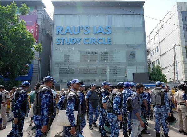 Security perso<em></em>nnel stand guard near a UPSC exam coaching centre after three civil services aspirants died when the ba<em></em>sement of the coaching centre was flooded following heavy rain, in New Delhi.