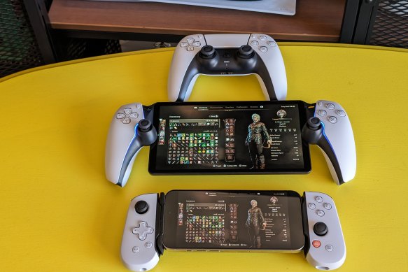 The PlayStation Portal (centre), with a standard DualSense co<em></em>ntroller and an iPhone in a Backbone One mount.