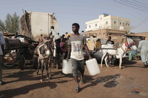 People gather to collect water in Khartoum, Sudan, last year. The Sudanese army and a rival paramilitary force have been battling for co<em></em>ntrol of the country since mid-April.